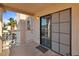 Outdoor patio area with sliding glass doors and a tropical view beyond the railing at 1928 Las Palmas Ln # 228, Laughlin, NV 89029