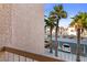 View from patio shows tropical trees, parking lot, and a building across the way at 1928 Las Palmas Ln # 228, Laughlin, NV 89029