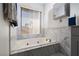 Bright bathroom featuring a tub with marble tile at 1942 Old Mill Ln, Henderson, NV 89014