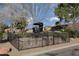 Iron carriage encased by a wrought iron fence, in a green community space with well maintained landscaping at 1942 Old Mill Ln, Henderson, NV 89014