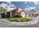 Corner-lot home with desert landscaping, a two-car garage, a well-maintained lawn, and mature trees at 1942 Old Mill Ln, Henderson, NV 89014