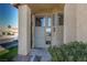 Welcoming front entrance with decorative door, ample windows, desert landscaping, and a well-maintained lawn at 1942 Old Mill Ln, Henderson, NV 89014