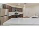Modern kitchen with dark cabinetry, stainless appliances, and a quartz countertop bar at 2037 Brush Stroke St, Henderson, NV 89044