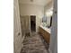 This bathroom features double sinks, wood cabinets, a glass shower, and luxury vinyl plank flooring at 2077 Alki Beach Ave, Laughlin, NV 89029