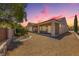 Home's rear exterior showcasing a covered patio, gravel landscaping, and privacy wall at 2114 Twin Falls Dr, Henderson, NV 89044