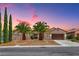 Charming single-story home with desert landscaping, palm trees, and a two-car garage under a colorful dusk sky at 2114 Twin Falls Dr, Henderson, NV 89044