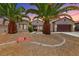 Attractive single-story home with desert landscaping and a two-car garage featuring a pair of palm trees at 2114 Twin Falls Dr, Henderson, NV 89044
