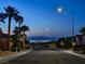 Night view of a street in a residential neighborhood, with palm trees and city lights in the distance at 2114 Twin Falls Dr, Henderson, NV 89044