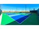 Wide view of the blue and green tennis courts with light posts and a dark green fence at 2114 Twin Falls Dr, Henderson, NV 89044