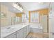 Bright bathroom with double vanity, soaking tub, and glass-enclosed shower at 2320 Anderson Park Dr, Henderson, NV 89044