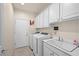 Functional laundry room with a utility sink and white cabinets at 2320 Anderson Park Dr, Henderson, NV 89044