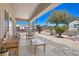 Covered patio with comfortable seating area, stone tile, and backyard views at 2320 Anderson Park Dr, Henderson, NV 89044