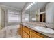 Bright bathroom featuring a marble countertop, double sinks, and a bathtub next to the window at 259 Baring Cross St, Henderson, NV 89074