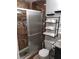 Bathroom featuring tiled walk-in shower with a glass door, toilet, and shelving unit at 266 Lyra Ln, Las Vegas, NV 89110