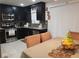 Modern kitchen and dining area boasts stainless steel appliances, black cabinetry, and tile backsplash at 266 Lyra Ln, Las Vegas, NV 89110