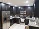 Updated kitchen with sleek black cabinets, stainless steel appliances, and granite countertops at 266 Lyra Ln, Las Vegas, NV 89110