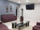 Living room featuring plum-colored sofas, a glass top coffee table, and neutral tile flooring at 266 Lyra Ln, Las Vegas, NV 89110