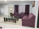 Living room featuring plum-colored sofas, a glass top coffee table, and neutral tile flooring at 266 Lyra Ln, Las Vegas, NV 89110
