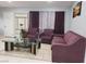 Living room featuring plum-colored sofas, a glass top coffee table, and neutral tile flooring at 266 Lyra Ln, Las Vegas, NV 89110