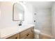 Modern bathroom with stylish vanity, arch mirror, and walk-in shower with stone floor at 2719 Frangipani Ct, North Las Vegas, NV 89031