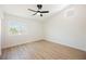 Bright bedroom features wood-look floors, white walls, ceiling fan, and natural light at 2719 Frangipani Ct, North Las Vegas, NV 89031