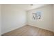 Simple bedroom features wood-look floors, white walls, and a bright window view at 2719 Frangipani Ct, North Las Vegas, NV 89031
