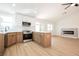 Open-concept kitchen and living area with modern fireplace and wood grain vinyl plank flooring at 2719 Frangipani Ct, North Las Vegas, NV 89031