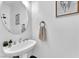Elegant powder room featuring a pedestal sink, round mirror, and modern decor at 2837 Canonero St, Las Vegas, NV 89142
