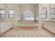 Bright bathroom featuring a large tub with tiled accents, double sinks and tiled floors at 2917 Broken Willow Cir, Las Vegas, NV 89117