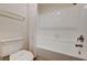 Clean white tiled shower and toilet in bathroom with bronze fixtures at 2917 Broken Willow Cir, Las Vegas, NV 89117