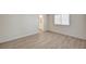 An empty bedroom with light wood floors and a view of a bathroom through an open door at 2917 Broken Willow Cir, Las Vegas, NV 89117