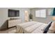 Staged bedroom featuring a plush bed, flat-screen television, and a light-filled window at 2917 Broken Willow Cir, Las Vegas, NV 89117