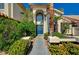 Elegant blue double door entrance with decorative glass, surrounded by lush landscaping at 2917 Broken Willow Cir, Las Vegas, NV 89117