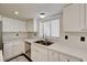 Bright kitchen featuring white cabinets, stainless steel sink, and sleek countertops at 2917 Broken Willow Cir, Las Vegas, NV 89117
