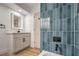 Modern bathroom featuring a vanity and mirror, with a shower featuring vertical blue tiling and black fixtures at 3104 Waterview Dr, Las Vegas, NV 89117