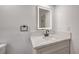 Bathroom showcasing a lighted mirror above a vanity with white countertop and dark, modern fixtures at 3104 Waterview Dr, Las Vegas, NV 89117