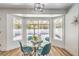 Inviting dining room with a glass table, blue chairs, hardwood floors, modern light fixture, and large windows at 3104 Waterview Dr, Las Vegas, NV 89117