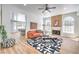 Bright living room featuring fireplace, modern ceiling fan, hardwood floors, large windows, and an artistic rug at 3104 Waterview Dr, Las Vegas, NV 89117