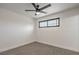 A cozy bedroom featuring neutral-toned carpet, a ceiling fan, and a horizontal window for natural light at 333 Rossmoyne Ave, North Las Vegas, NV 89030