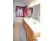 Bathroom featuring a double sink vanity, and tub beneath window with red curtains at 3519 W Red Coach Ave, North Las Vegas, NV 89031