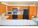 Well-lit kitchen features wood cabinets, black appliances, and tiled countertops for a functional cooking space at 3519 W Red Coach Ave, North Las Vegas, NV 89031