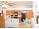 Inviting eat-in kitchen with breakfast bar, warm wood cabinetry and appliances offers a cozy gathering spot at 3519 W Red Coach Ave, North Las Vegas, NV 89031
