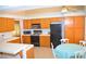 Cozy kitchen featuring wood cabinetry, tile countertops, and adjacent breakfast nook offers a homely atmosphere at 3519 W Red Coach Ave, North Las Vegas, NV 89031