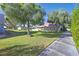 Inviting exterior view of home with large trees, green lawn, and walkway to the front entrance at 3753 Heritage Ave, Las Vegas, NV 89121