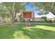 Exterior front view of community building with green lawn, trees, bench and American flag at 3753 Heritage Ave, Las Vegas, NV 89121