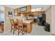 Bright kitchen features breakfast bar seating, oak cabinetry, and black appliances at 3753 Heritage Ave, Las Vegas, NV 89121