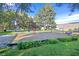 Community playground with swing sets, play equipment, green grass, and mature trees at 3753 Heritage Ave, Las Vegas, NV 89121