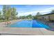Community swimming pool surrounded by mature trees, tennis court and a building with covered picnic tables at 3753 Heritage Ave, Las Vegas, NV 89121
