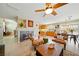 Cozy living room with a fireplace, ceiling fan, and tile flooring, open to the kitchen and dining area at 419 Alonzo Ct, Las Vegas, NV 89123