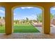 Beautiful backyard featuring an artificial grass lawn, manicured landscaping, and a cozy fire pit under a covered patio at 424 Vigo Port St, Las Vegas, NV 89138